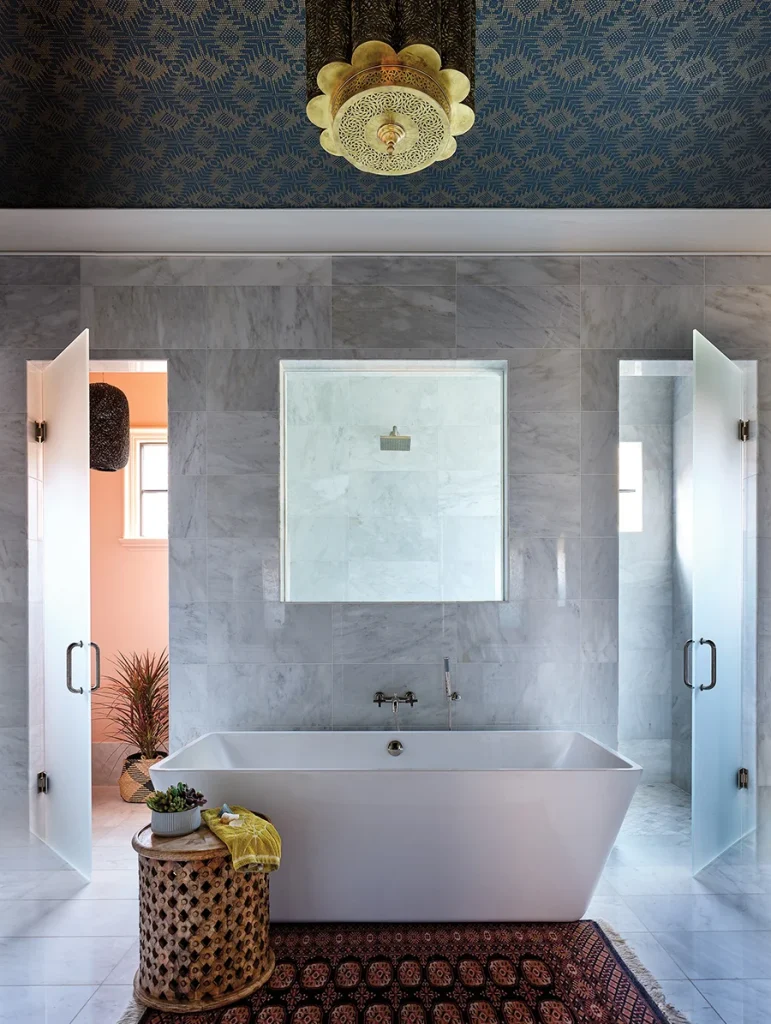 Annie personalized the primary bathroom by adding details like wallpaper on the ceiling and a Moroccan light fixture.