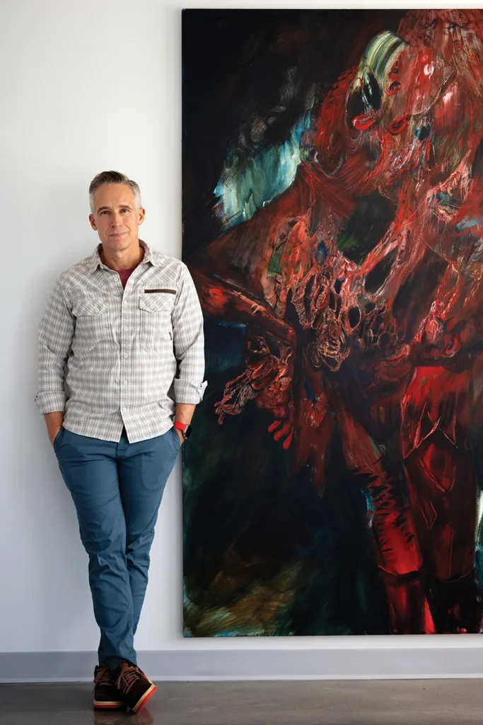 Artist Jonathan Justice in front of artwork
