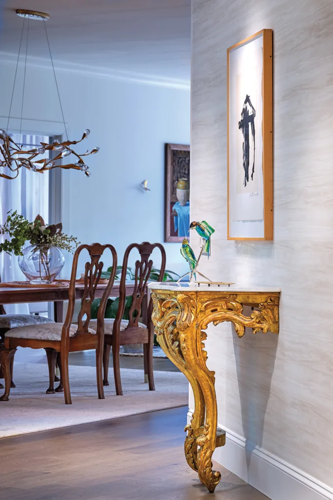 Console Table with glass parrot sculpture on top of it.